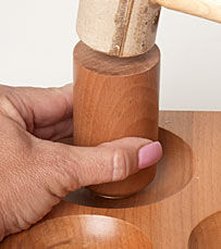 Mallet hitting wooden punch 